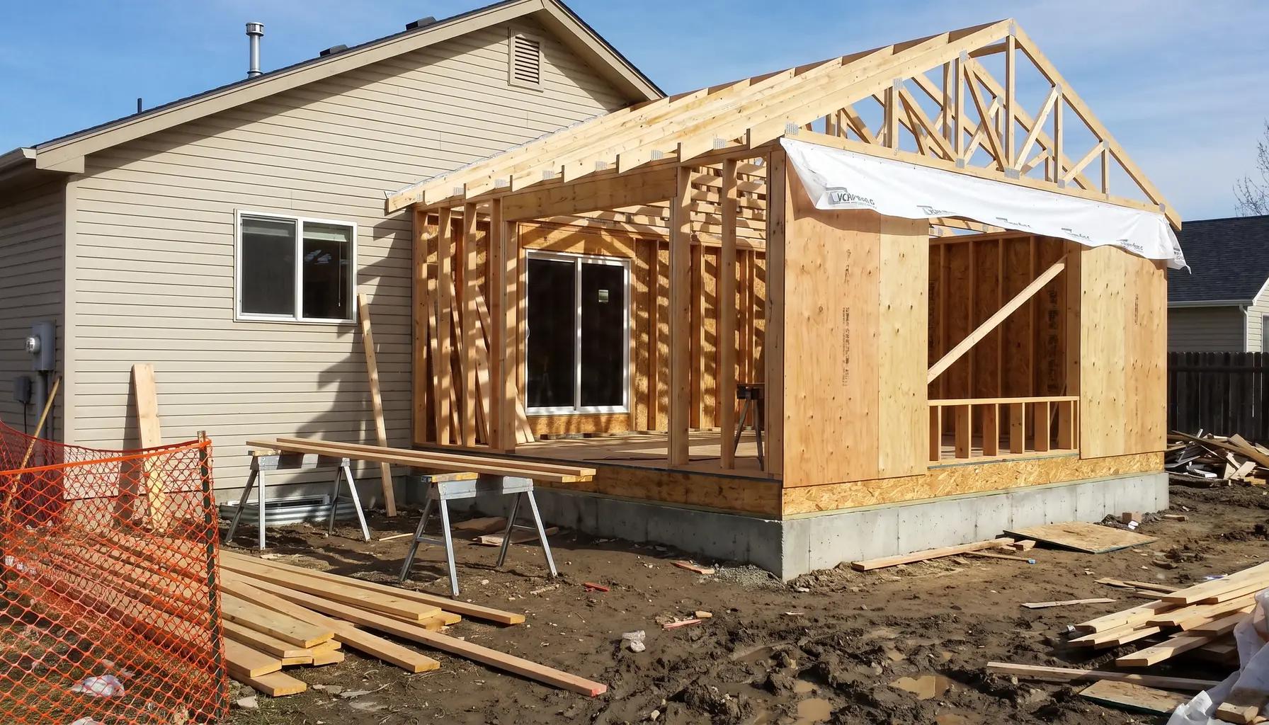 Home addition under construction with new framing, roof trusses, and foundation tied into an existing Boise house