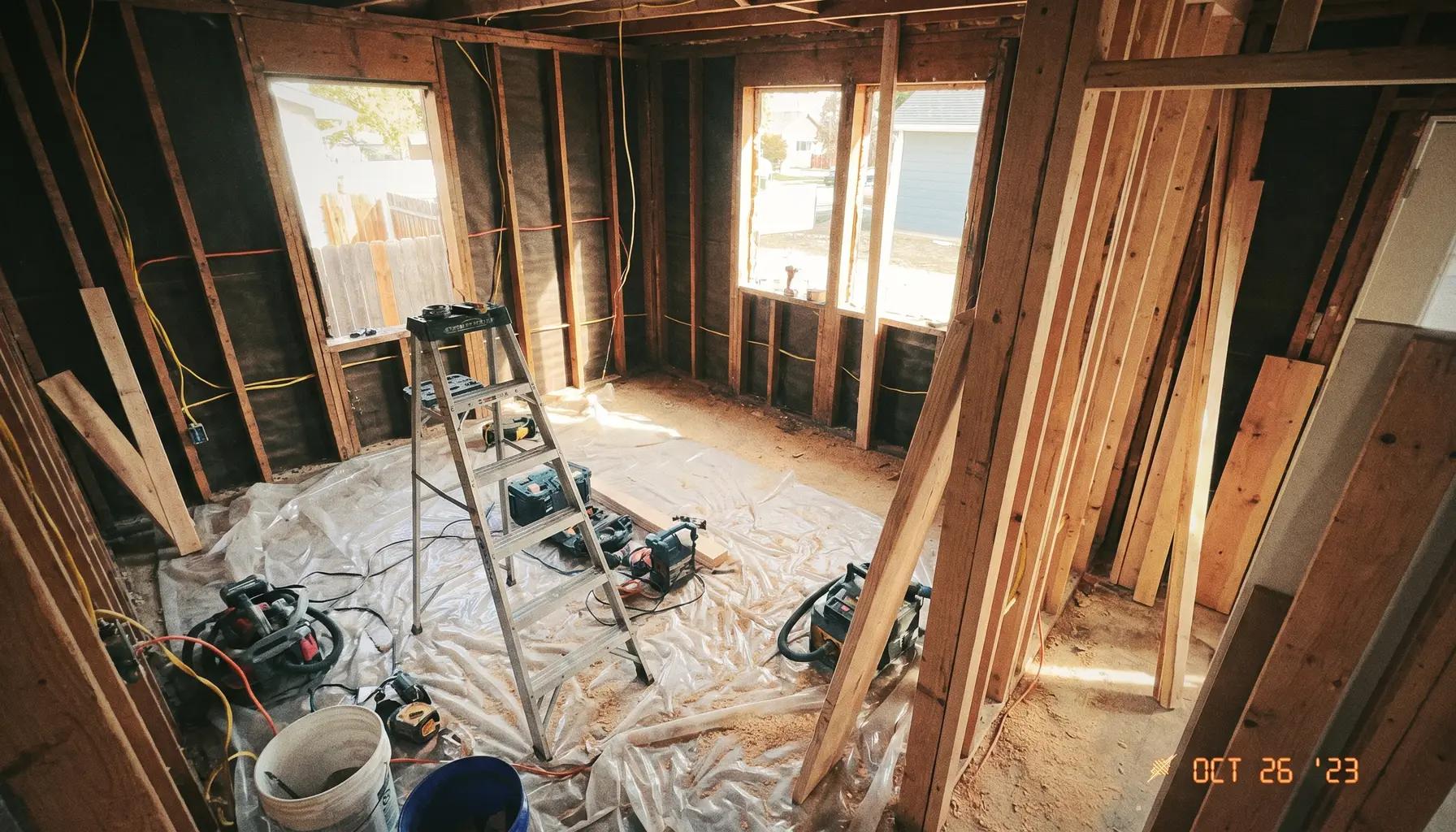 Whole-home renovation in progress, an interior stripped to the studs with new wiring and floor protection in a Boise house